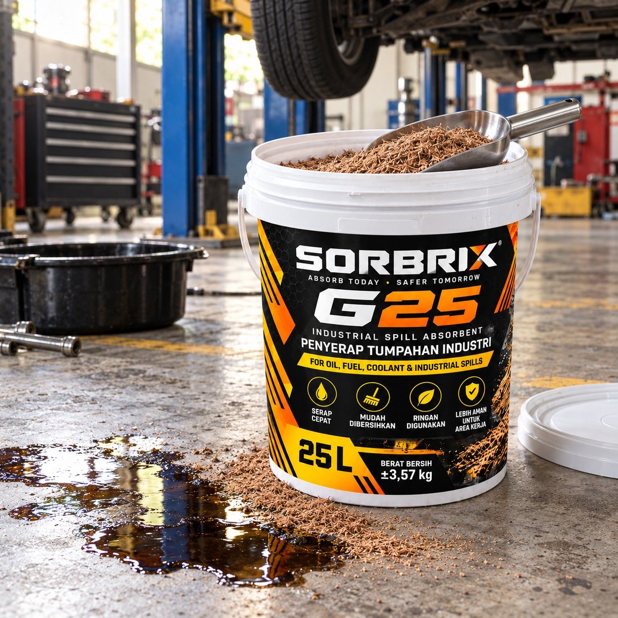 Pail Sorbrix G25 berisi absorben granular di lantai bengkel, di samping genangan oli gelap yang sudah ditaburi granul.